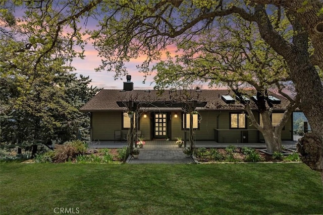 30140 Tuttle Ct, Tehachapi, CA 93561 - back of property at dusk featuring a lawn, a chimney, a porch, and french doors