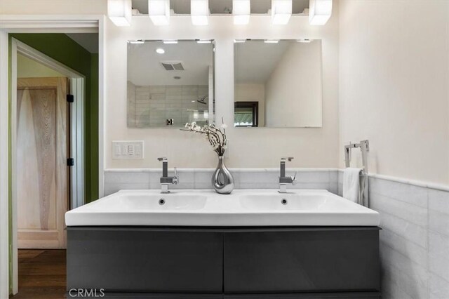 30140 Tuttle Ct, Tehachapi, CA 93561 - bathroom featuring double vanity, visible vents, a sink, and a wainscoted wall