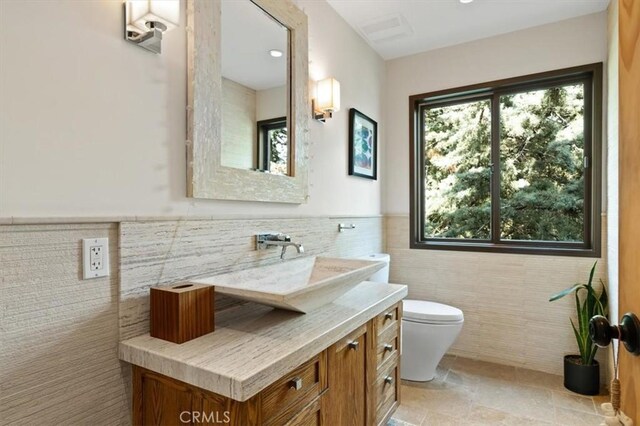 30140 Tuttle Ct, Tehachapi, CA 93561 - bathroom with wainscoting, tile walls, vanity, and toilet