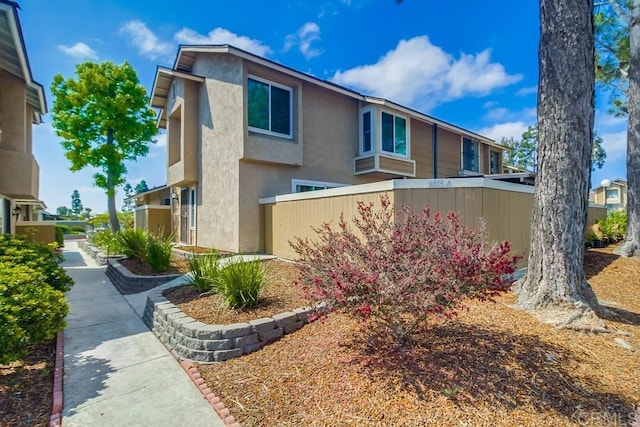 view of front facade with fence and stucco siding