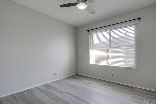 unfurnished room with baseboards, ceiling fan, and wood finished floors