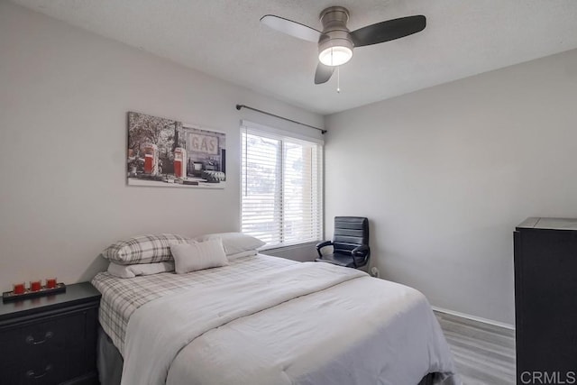 bedroom featuring baseboards, a ceiling fan, and wood finished floors