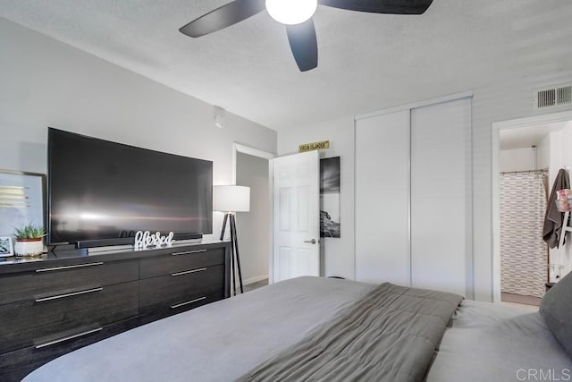 bedroom with ceiling fan, visible vents, and a closet