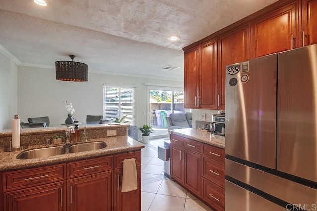 kitchen featuring a sink, freestanding refrigerator, light tile patterned floors, visible vents, and ornamental molding