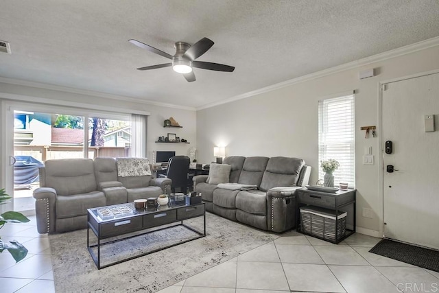 living area with light tile patterned floors, crown molding, a ceiling fan, and a wealth of natural light