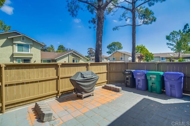 view of patio featuring fence, a residential view, and area for grilling
