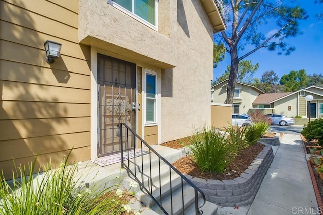doorway to property featuring stucco siding