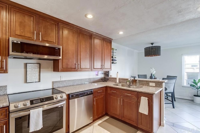 kitchen featuring a sink, appliances with stainless steel finishes, and brown cabinets