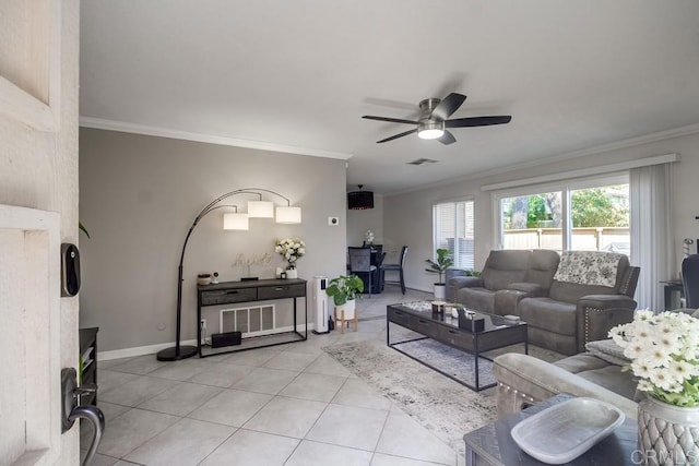 living area featuring crown molding, ceiling fan, baseboards, and light tile patterned floors