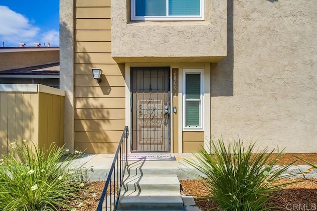 entrance to property with stucco siding