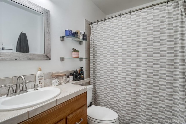 full bathroom with vanity, tasteful backsplash, toilet, and curtained shower