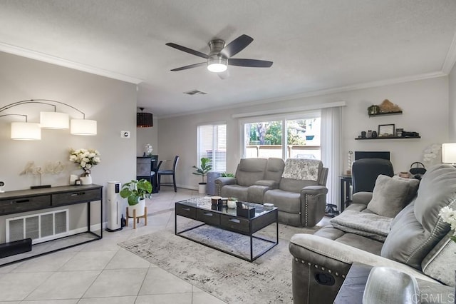 tiled living area with visible vents, crown molding, and ceiling fan