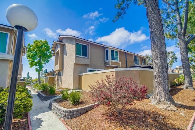 view of front of property with stucco siding and fence