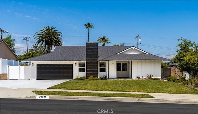 ranch-style house with fence, an attached garage, a front yard, a chimney, and driveway