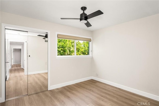 unfurnished bedroom with baseboards, ceiling fan, a closet, and light wood-type flooring