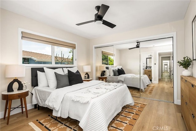 bedroom with light wood-style floors, baseboards, a ceiling fan, and a closet