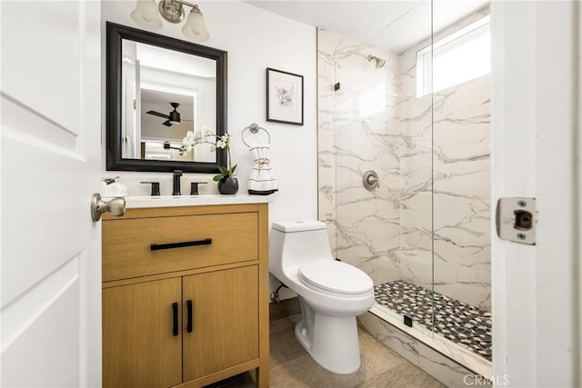 bathroom featuring vanity, a marble finish shower, and toilet