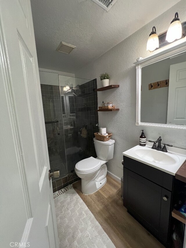 8871 Knollwood Pl, Rancho Cucamonga, CA 91730 - full bathroom featuring toilet, vanity, a textured wall, a stall shower, and a textured ceiling