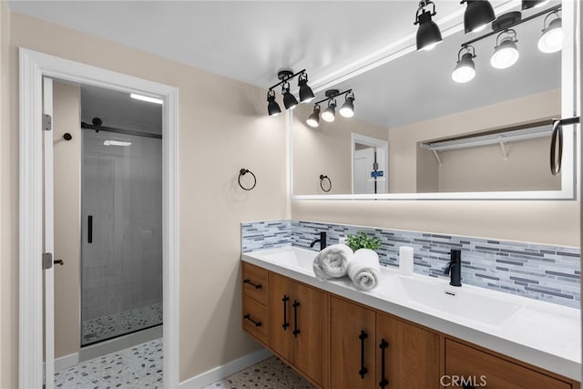 full bathroom featuring a sink, backsplash, and a shower stall