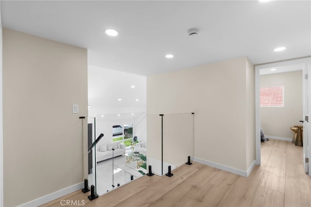 corridor featuring recessed lighting, baseboards, a wealth of natural light, and light wood finished floors