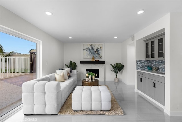 living room featuring a premium fireplace, recessed lighting, and visible vents
