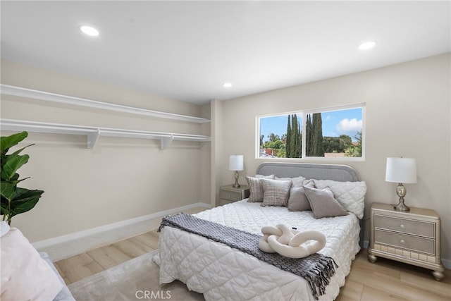 bedroom with baseboards, recessed lighting, and wood finished floors