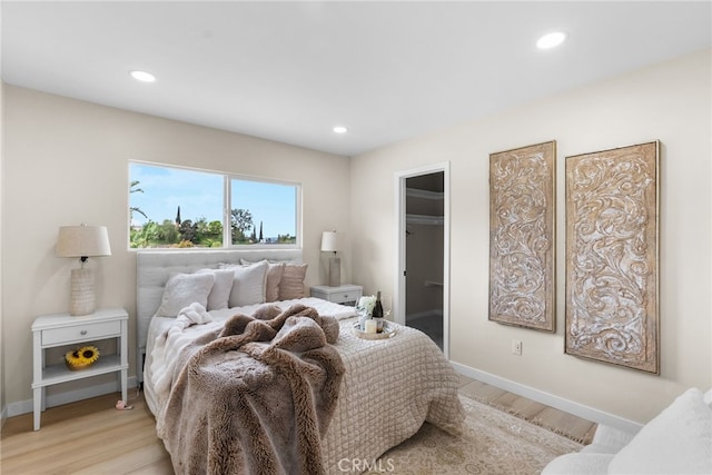 bedroom with light wood-style floors, baseboards, and recessed lighting