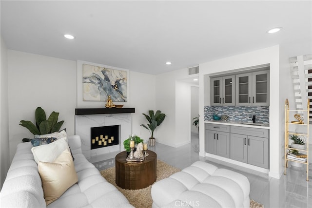 living area with visible vents, recessed lighting, baseboards, and a high end fireplace