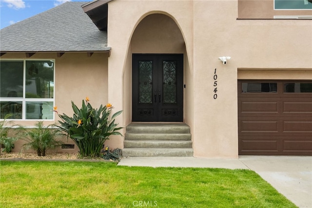 doorway to property featuring roof with shingles, stucco siding, a yard, and french doors