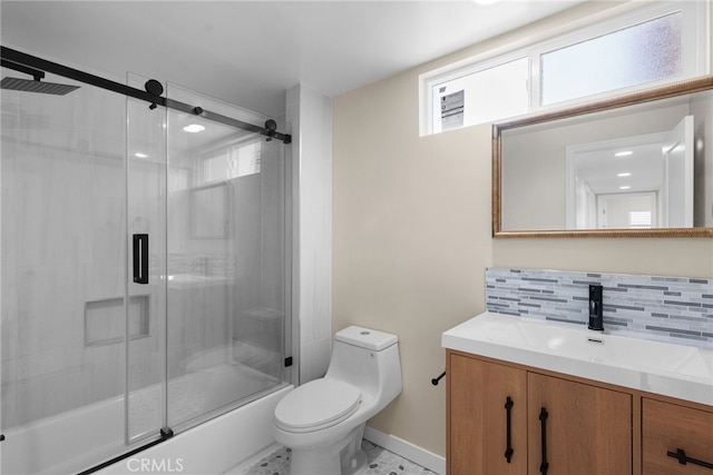 bathroom with backsplash, vanity, baseboards, combined bath / shower with glass door, and toilet