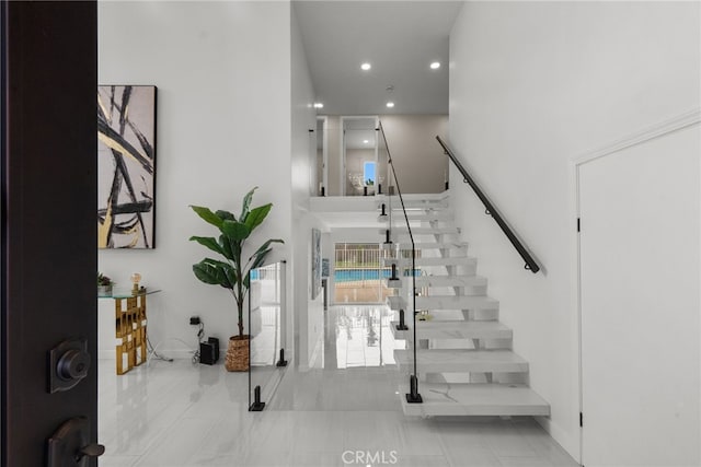 entryway featuring recessed lighting, a high ceiling, and stairway