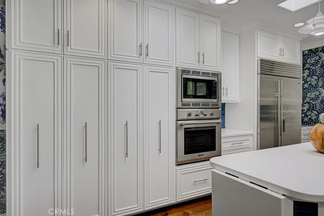 5594 Avenida Sosiega W Unit B, Laguna Woods, CA 92637 - kitchen with crown molding, built in appliances, dark wood-type flooring, light countertops, and white cabinets