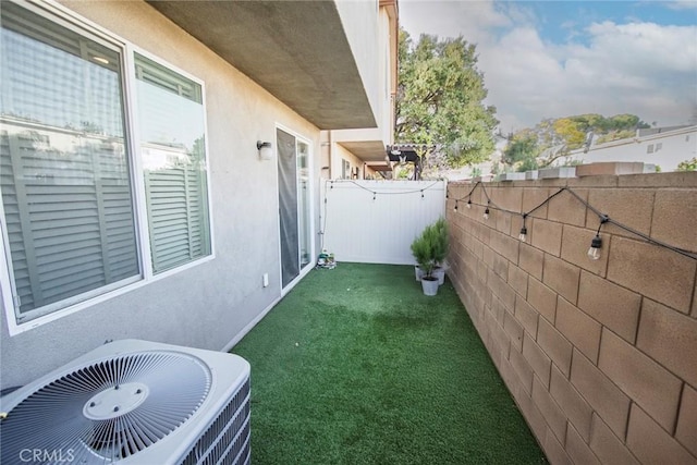 view of yard with central air condition unit and fence