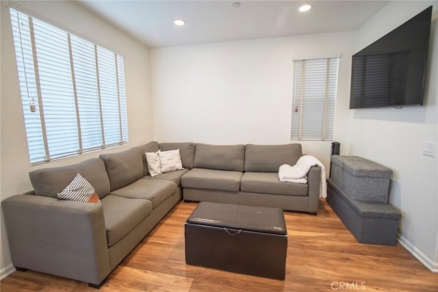 living room featuring recessed lighting, baseboards, and light wood finished floors