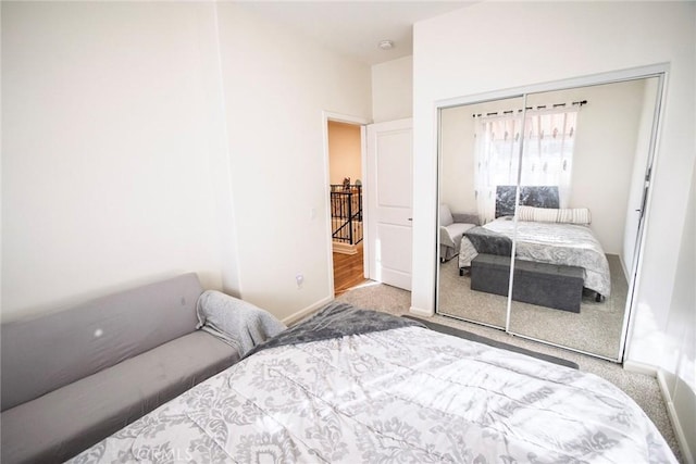 carpeted bedroom with baseboards and a closet