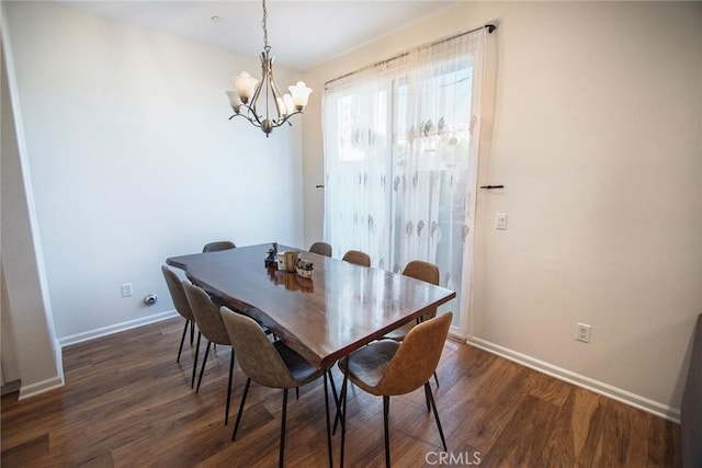 dining space with baseboards, dark wood finished floors, and a chandelier