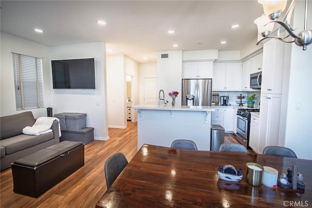 dining area featuring recessed lighting, baseboards, wood finished floors, and visible vents