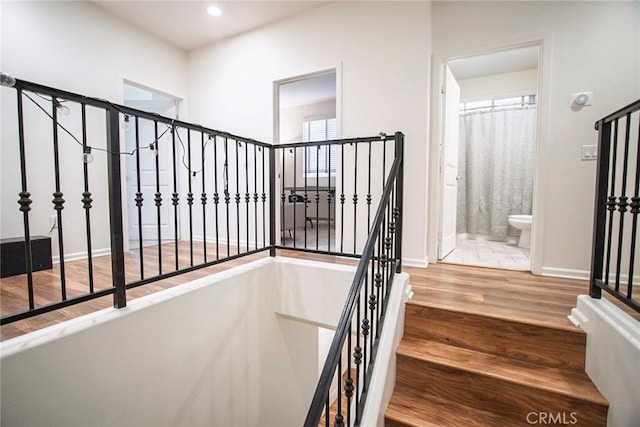 staircase with baseboards, recessed lighting, and wood finished floors