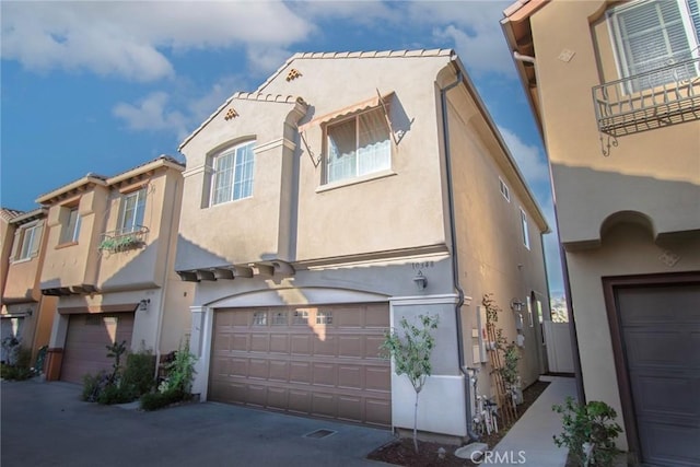 multi unit property with stucco siding and an attached garage