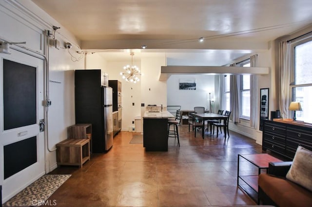 215 W 7th St Unit 803, Los Angeles, CA 90014 - kitchen with a chandelier, a kitchen breakfast bar, freestanding refrigerator, and hanging light fixtures