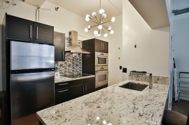 215 W 7th St Unit 803, Los Angeles, CA 90014 - kitchen featuring stainless steel appliances, wall chimney range hood, a sink, a chandelier, and decorative backsplash