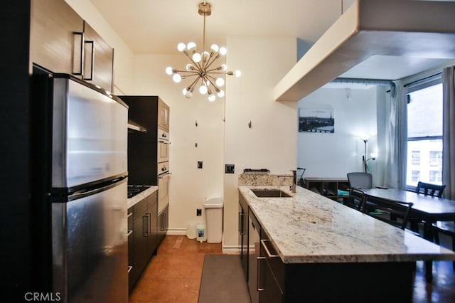 215 W 7th St Unit 803, Los Angeles, CA 90014 - kitchen featuring freestanding refrigerator, a sink, a chandelier, pendant lighting, and light stone counters