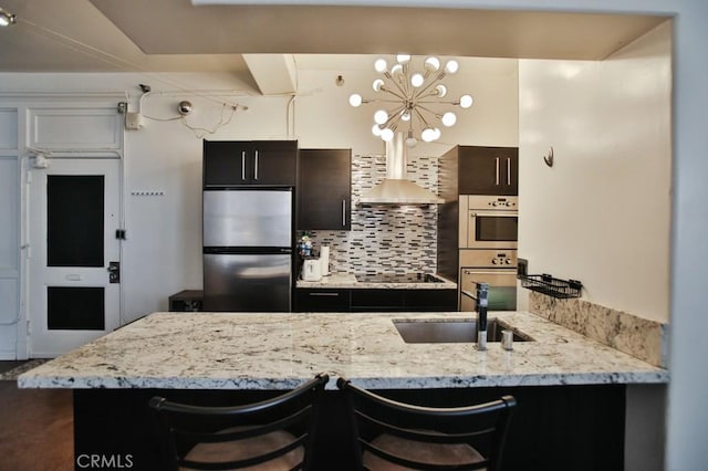 215 W 7th St Unit 803, Los Angeles, CA 90014 - kitchen with appliances with stainless steel finishes, a sink, decorative backsplash, and a kitchen breakfast bar
