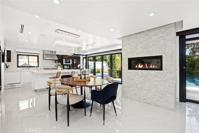 dining area with recessed lighting, a stone fireplace, and a wealth of natural light
