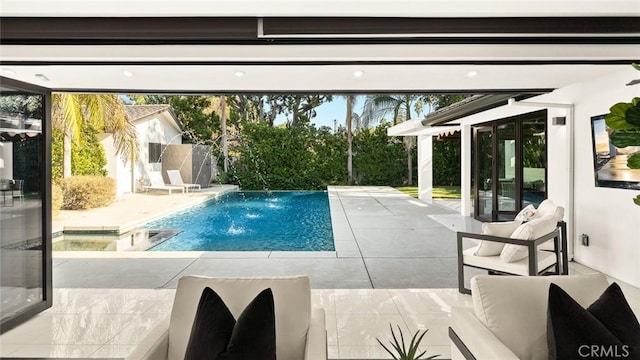 view of swimming pool featuring a pool with connected hot tub and a patio area