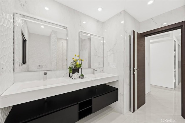 full bath with double vanity, a sink, marble finish floor, and recessed lighting