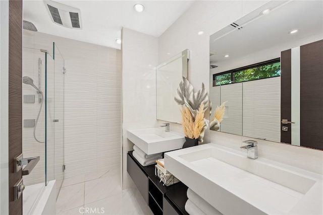 bathroom featuring recessed lighting, visible vents, tiled shower, and vanity