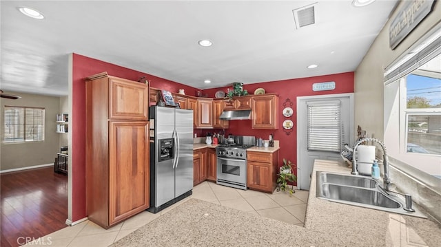 6048 Fidler Ave, Lakewood, CA 90712 - kitchen with stainless steel appliances, under cabinet range hood, a sink, light tile patterned floors, and recessed lighting