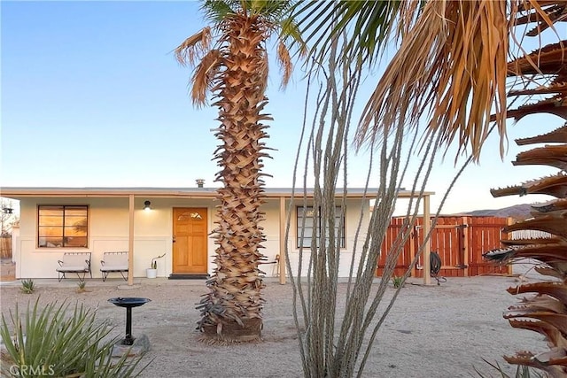 rear view of property with fence and stucco siding