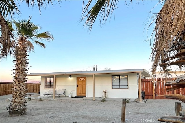 ranch-style house featuring fence